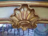 a mirror that has a gold frame on it