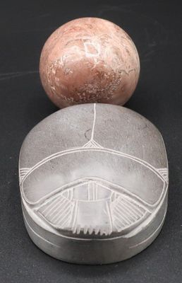 une image représentant un objet en pierre surmonté d'une boule