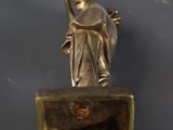 bronze statue of a woman holding a bird on top of a box