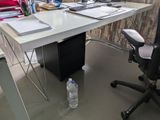 a desk with a computer and a bottle of water on it