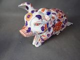 une petite figurine représentant un cochon avec des fleurs sur la tête