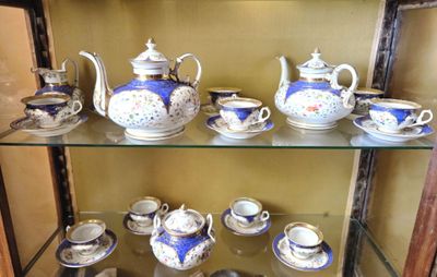 une vitrine en verre contenant toute une gamme de tasses à thé et à café
