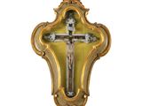 une croix accrochée au mur, encadrée d'un cadre doré