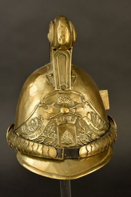 casque plaqué or orné d'un aigle et d'un bouclier, posé sur un socle, sur fond noir