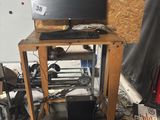 a computer sitting on top of a wooden stand