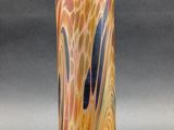 an orange and blue vase sitting on top of a gray surface