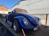 a blue vw beetle on a flatbed tow truck