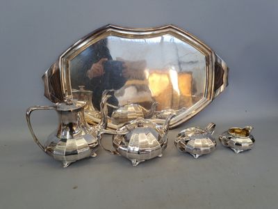 un plateau en argent avec un miroir et un service à thé en argent posé sur une table