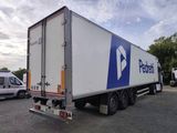 un camion qui est garé sur un terrain avec d'autres camions
