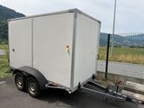 a small white trailer parked on the side of the road