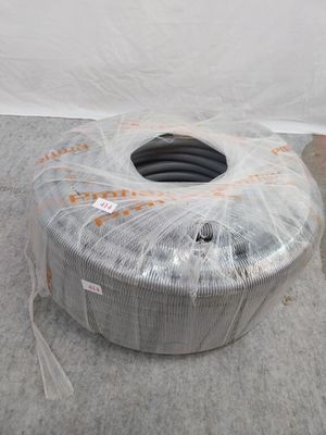 une grosse bobine de fil métallique enveloppée dans du plastique, posée par terre