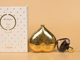un gros plan sur un flacon de parfum et un coffret posés sur une table