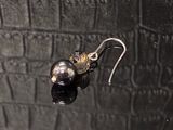 une paire de boucles d'oreilles sur une surface noire