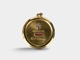 a close up of a gold medal with a red stone in the center