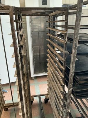 many trays of food on a rack in the kitchen