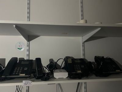 de nombreux téléphones sur les étagères de la pièce