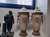 trois vases posés sur une étagère à côté d'une statue