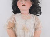 an image of a doll with black hair and a white dress