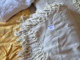 une couverture blanche et une couverture jaune sur un lit