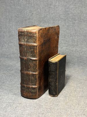 two old books are sitting on a table next to each other