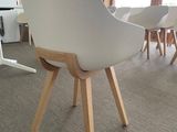 a white chair sitting in a room with a table and chairs