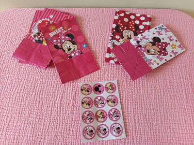 pink minnie mouse party bags and stickers on a pink blanket