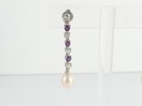 pair of pearl and amethorate earrings on display in a glass case
