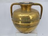 a gold vase with a handle on a white surface