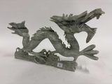 statue d'un dragon perché sur une branche, avec une étiquette autour du cou