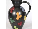 un vase noir orné de papillons colorés peints dessus