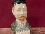 une figurine en céramique représentant un homme barbu et moustachu