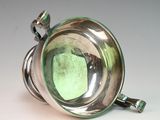 a silver cup with a green glass inside of it