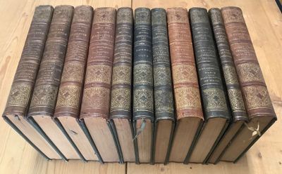 several old books are stacked on top of each other on a wooden table