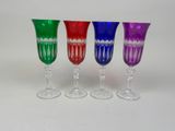 four wine glasses are lined up in a row on a white surface
