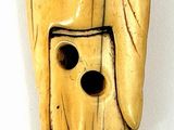 a wooden mask that is on display on a white surface