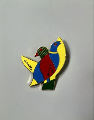 a colorful bird that is sitting on a white surface