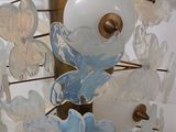 a glass sculpture of flowers and butterflies on a stand