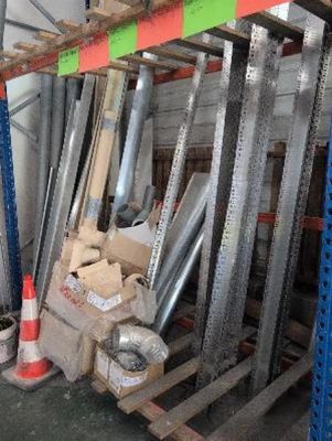un tas de tuyaux métalliques posés sur une palette dans un entrepôt