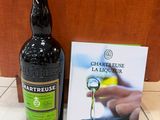une bouteille d'alcool posée à côté d'un livre, par terre