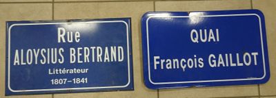 deux panneaux de signalisation bleus accrochés à un mur dans des toilettes publiques