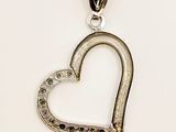 a close up of a heart shaped pendant on a white background