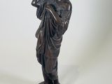 statue en bronze représentant une femme tenant une fleur dans la main droite