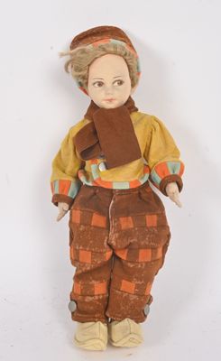 une image représentant une poupée à l'effigie d'une femme portant un chapeau et une écharpe