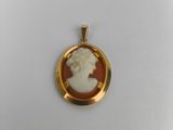 a close up of a gold plated pendant with a picture of a woman