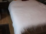 a white bed with orange pillows in a small room