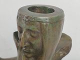 a bronze statue of a woman holding a flower pot