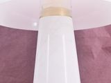 a close up of a white table lamp on a pink surface