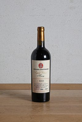 une bouteille de vin rouge posée sur une table en bois