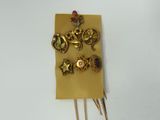 a picture of a gold brooch and pins on a piece of paper
