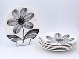 quatre assiettes ornées de motifs en noir et blanc